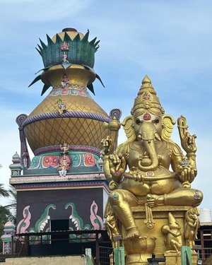 A golden Gaṇeśa mūrti beside a temple kalaśa